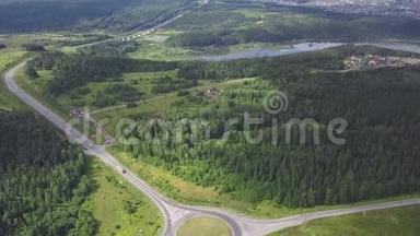 乡村环形交叉路口的俯视图。 剪辑。 林区环形公路交通。 在森林湖岸的城市